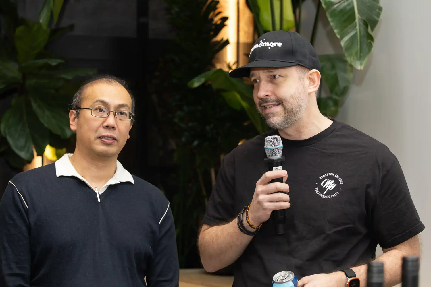 Two men, one speaking into a microphone.